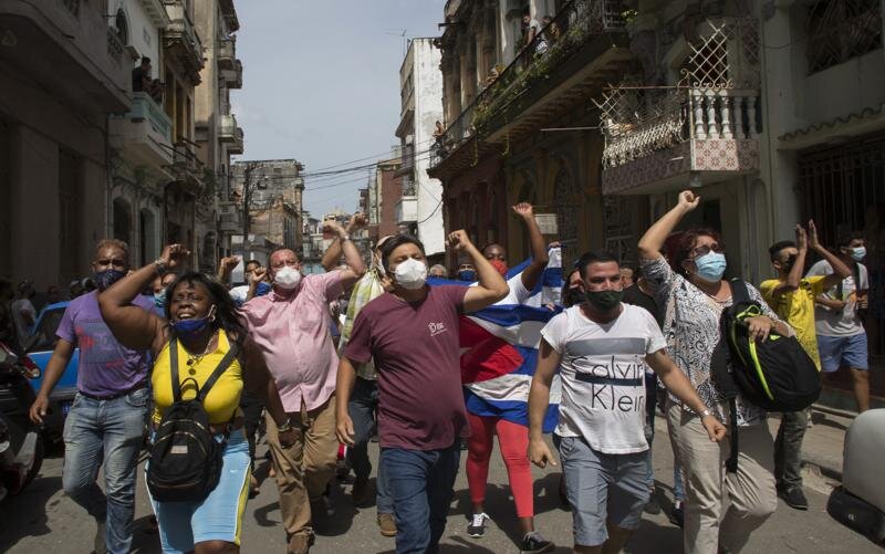  Government supporters shout slogans as anti-government protesters march in Havana, Cuba, Sunday, July 11, 2021. Photo Credit: AP Photo/Ismael Francisco